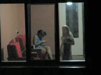 Brunette and blonde girls through hostel window